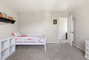 Bedroom featuring light colored carpet and baseboards