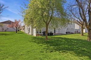 View of grassy yard featuring a patio