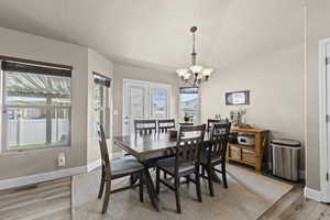 Dining room with light wood-style floors and hanging lights