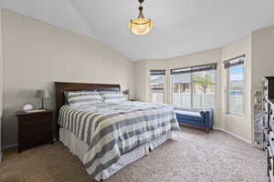 Bedroom with carpet flooring, lofted ceiling, and access to outside
