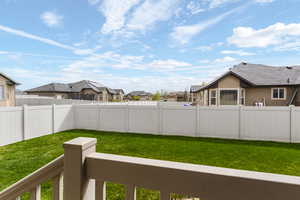 Fenced backyard with a residential view and a balcony
