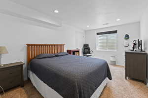 Bedroom with light carpet, recessed lighting, and a textured ceiling