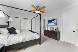 Carpeted bedroom featuring ornamental molding and ceiling fan