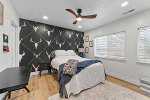 Bedroom with an accent wall, wallpapered walls, recessed lighting, a ceiling fan, and light wood-type flooring