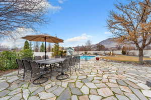 Fenced backyard featuring a patio area, outdoor dining space, and a mountain view