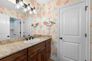 Bathroom with wallpapered walls and vanity