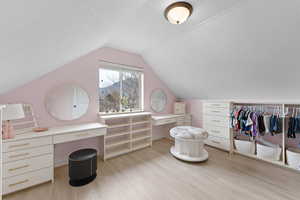 Walk in closet with light wood finished floors