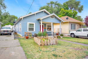 Bungalow-style home with a front lawn and covered porch