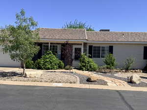 Ranch-style home with a tile roof, an attached garage, and driveway