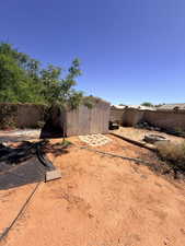 Fenced backyard with a storage unit and a fire pit
