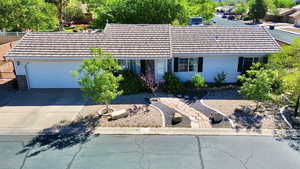 View of front of home with an attached garage, a tiled roof, and concrete driveway