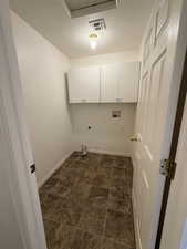 Laundry room with a textured ceiling, cabinet space, washer hookup, and electric dryer hookup