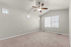 Unfurnished room featuring carpet flooring, lofted ceiling, and a ceiling fan
