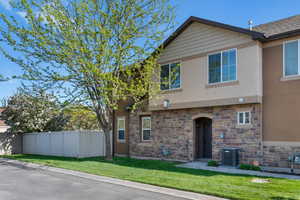 View of front facade featuring stucco siding and stone siding
