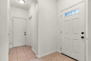 Entryway with light tile patterned flooring