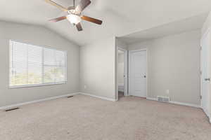 Unfurnished bedroom with carpet flooring, lofted ceiling, a ceiling fan, and ensuite bathroom