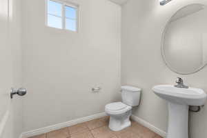 Half bathroom featuring toilet and light tile patterned floors