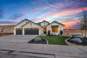 Modern farmhouse featuring a garage, a front yard, concrete driveway, and stucco siding