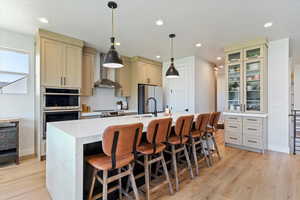 Kitchen featuring stainless steel appliances, a kitchen breakfast bar, a center island with sink, and cream cabinets