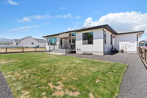 Rear view of property featuring a fenced backyard and stucco siding