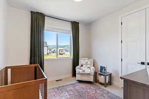 Bedroom with light carpet and a crib