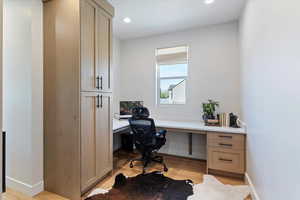 Office area with built in study area, light wood-style flooring, and recessed lighting