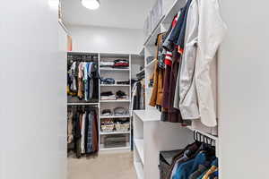 Walk in closet featuring light colored carpet