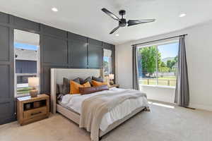 Bedroom featuring a decorative wall, light colored carpet, ceiling fan, and recessed lighting