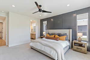 Bedroom featuring light carpet, a decorative wall, ceiling fan, ensuite bathroom, and recessed lighting