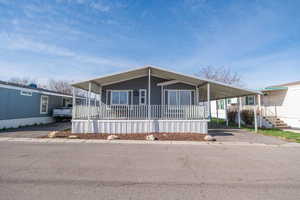 Manufactured / mobile home with a large porch, an attached carport, and driveway