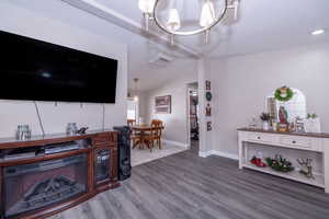 Living room featuring a chandelier, lofted ceiling, and dark wood-style floors