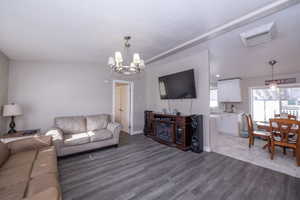 Living room featuring hanging lights, light wood finished floors, and cooling unit