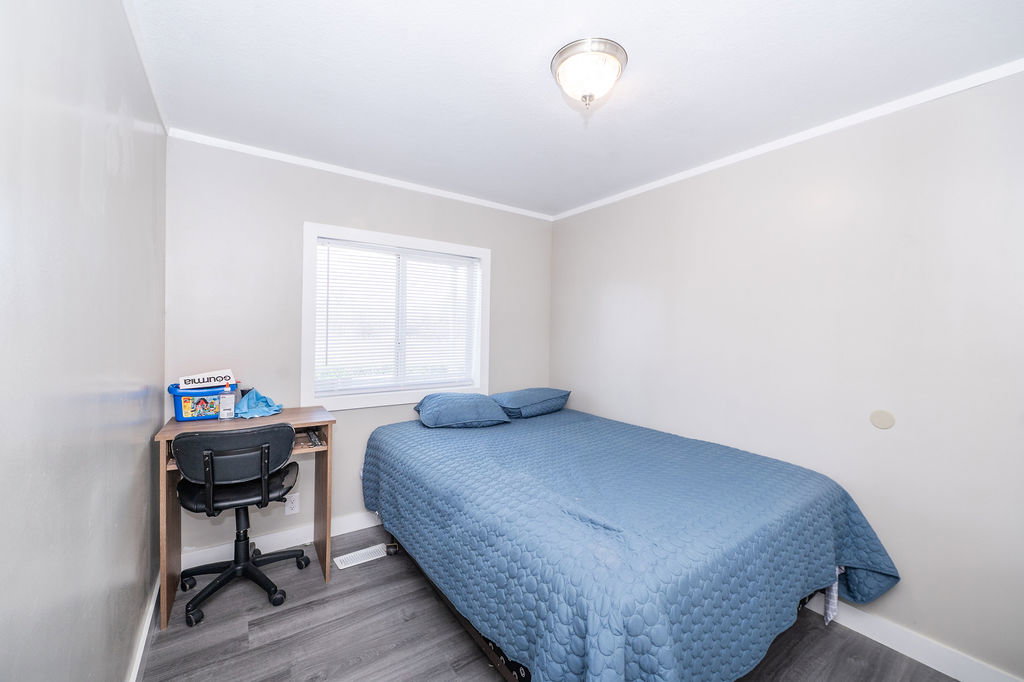 Bedroom with wood finished floors, a desk, and ornamental molding