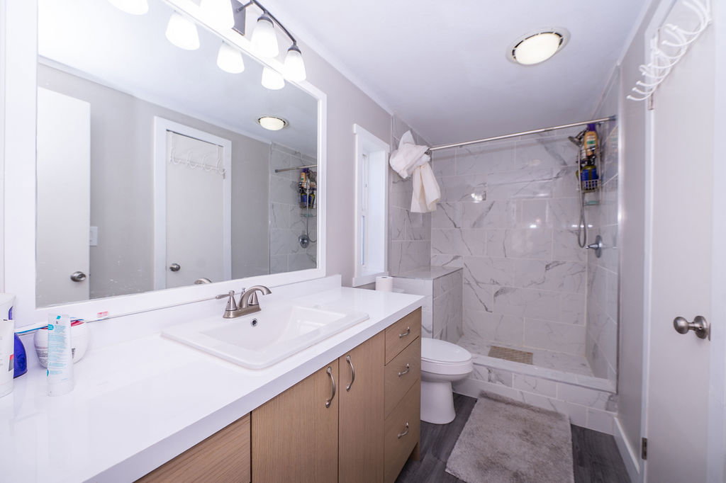 Bathroom featuring vanity and a marble finish shower