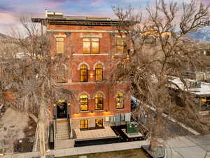 Italianate home featuring roof mounted solar panels, brick siding, and a mountain view