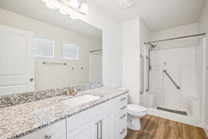 Full bathroom featuring vanity, a shower stall, and dark wood finished floors