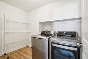 Laundry room featuring light wood-style flooring and washer and dryer