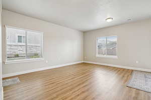Unfurnished room with light wood-type flooring and baseboards