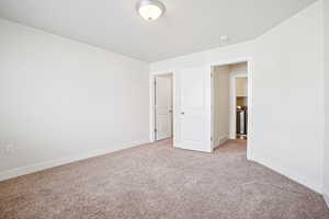 Unfurnished bedroom featuring carpet and baseboards