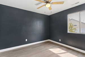Unfurnished room with ceiling fan, light wood-style floors, and a textured wall