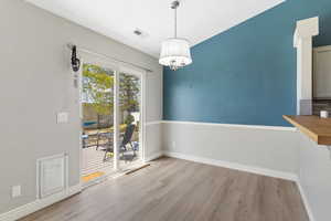 Unfurnished dining area featuring light wood-type flooring and baseboards