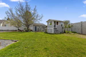 Fenced backyard with an outbuilding