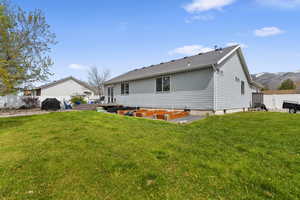 Rear view of property featuring a vegetable garden, a fenced backyard, a gate, and a mountain view