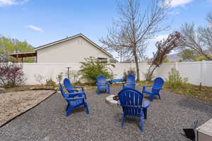 Fenced backyard featuring an outdoor fire pit and a patio area