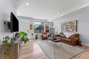 Living area featuring light wood finished floors and recessed lighting