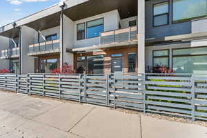 View of front facade with stucco siding, a fenced front yard, and a gate