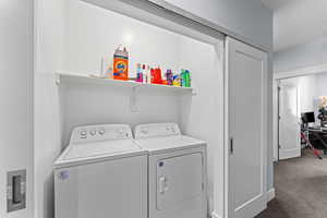 Laundry area with dark carpet and separate washer and dryer
