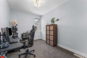 Office space with dark carpet and baseboards