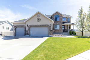 View of front of home with a garage, driveway, stucco siding, a porch, and brick siding