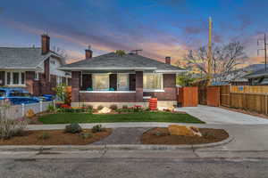 Bungalow-style house with a chimney, brick siding, and a shingled roof